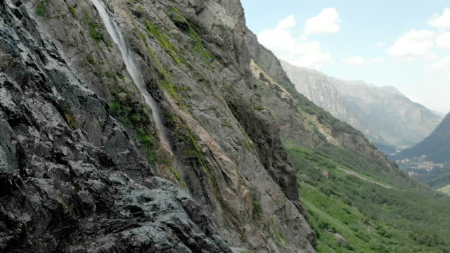 Tracking-and-top-shot-Air-shot-from-a-stream-of-water-splashing-waterfall-on-a-rock-wall-in-the-Caucasus-Mountains.-Around-the-jet-of-the-waterfall