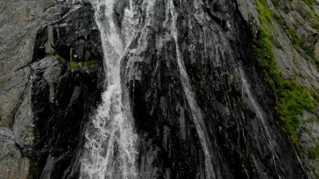 Tracking-and-top-shot-Air-shot-from-a-stream-of-water-splashing-waterfall-on-a-rock-wall-in-the-Caucasus-Mountains.-Around-the-jet-of-the-waterfall