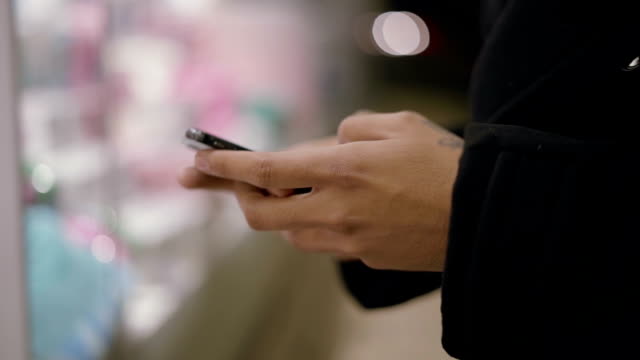 Männliche-Hände-mit-Smartphone-auf-Straße-am-Abend