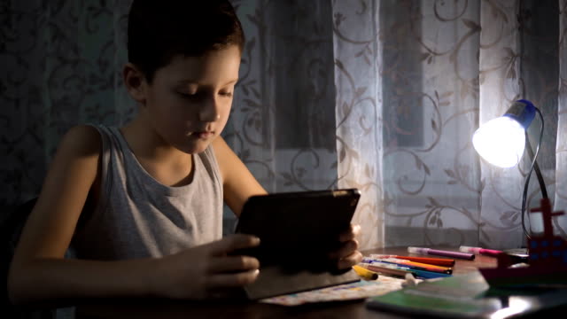 Child-Uses-Tablet-For-Studying,-Boy-Writing-Homework-in-Night-Internet-Usage-FullHD
