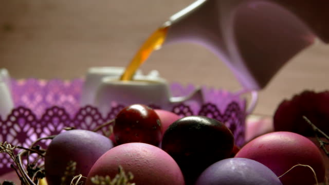 Colored-pink-Easter-egg-lies.-Tea-poured-in-the-cup