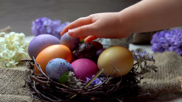 Kinderhand-legt-festlich-gefärbtes-Ei