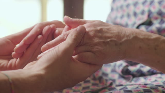Die-junge-Frau-hilft-ihrer-Großmutter,-die-Hände-zu-nehmen.