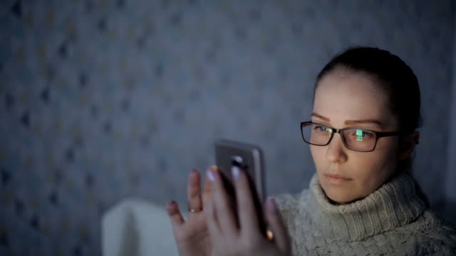 Mujer-caucásica-utiliza-teléfono-inteligente,-la-pantalla-del-teléfono-se-refleja-en-las-gafas-red-social,-tecnología,-concepto-de-comunicación