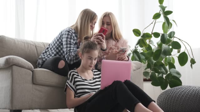 Mädchen-im-Teenageralter,-die-mit-dem-Surfen-in-sozialen-Medien-auf-Handy-und-Laptop-beschäftigt-sind