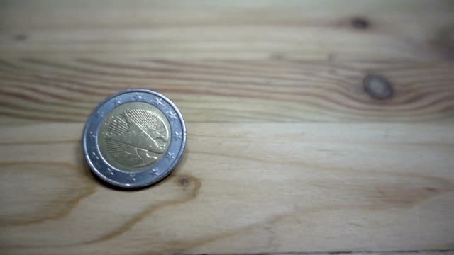 Zeitlupe-der-Euro-Münzrotation-auf-einem-Holztisch.