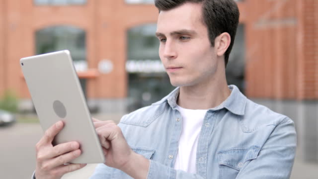 Young-Man-Using-Tablet-Outdoor