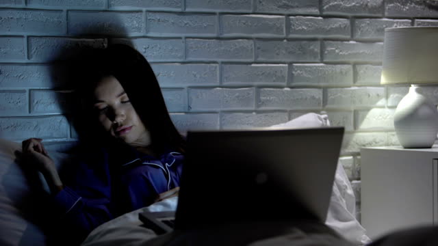 Chica-durmiendo-frente-a-la-computadora-portátil-por-la-noche,-adicción-a-Internet,-red-social