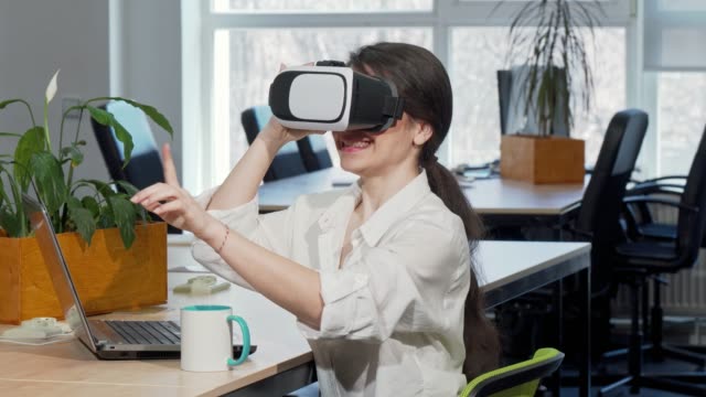 Lovely-excited-businesswoman-laughing-joyfully,-using-3d-virtual-reality-headset