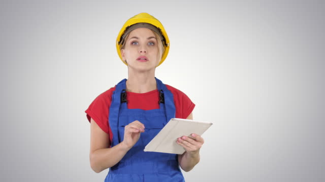 Woman-engineer-checking-building-plan-on-touchpad-and-looking-at-objects,-buildings-around-her-on-gradient-background