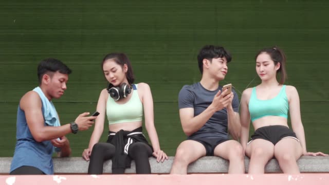 Asiáticos-jóvenes-y-chica-relexing-ejercicio-después-del-deporte-corriendo