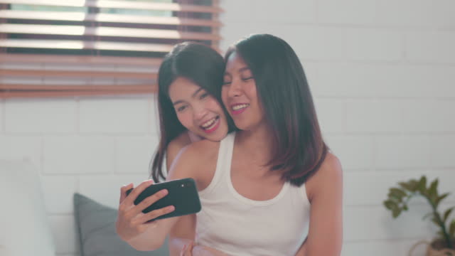 Asian-influencer-Lesbian-couple-vlog-video-to-social-media-after-wake-up-lying-on-bed-in-bedroom.