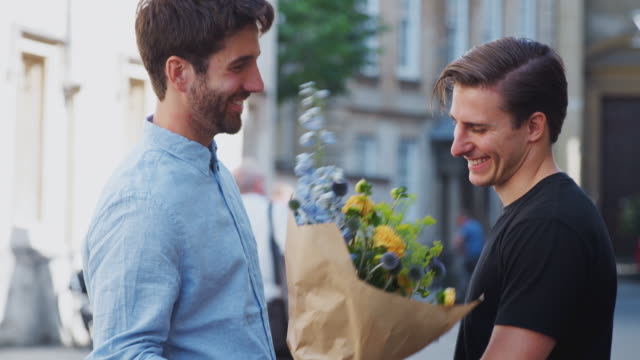 Liebenmännliche-Homosexuell-Paar-Treffen-auf-Datum-geben-Partner-Umarmung-und-Blumenstrauß