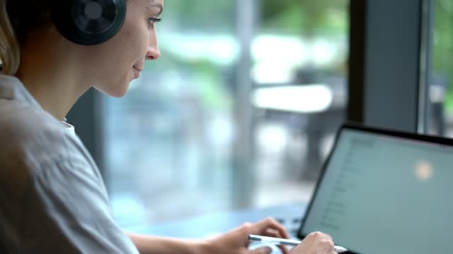 Kaukasische-Mädchen-in-Bluetooth-Kopfhörer-für-Geräuschunterdrückung-Eingabe-Nachricht-auf-Laptop-Computer