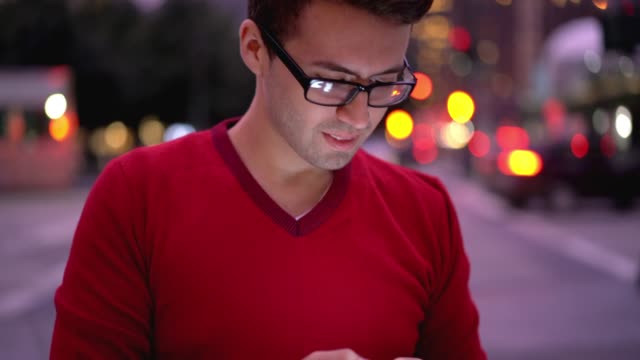 Guapo-blogger-masculino-español-en-anteojos-para-corrección-de-la-visión-actualización-notificación-en-el-teléfono-celular
