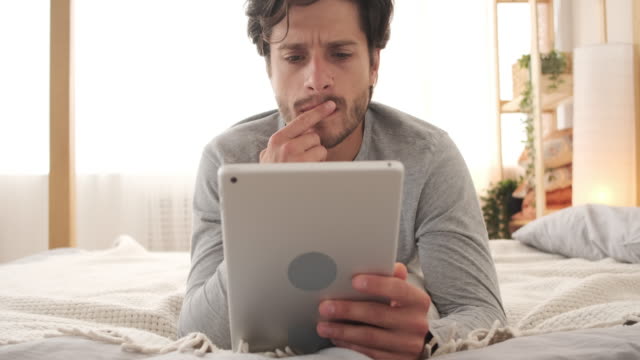 Hombre-usando-tableta-digital-en-la-cama