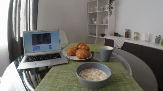 POV-der-Frau-Essen-Cornflakes-und-Video-auf-Laptop-ansehen