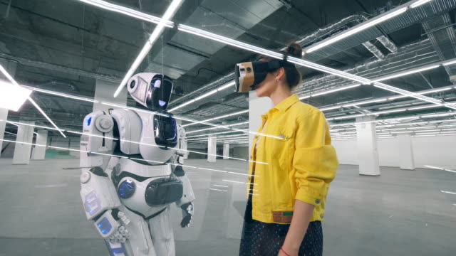 Robot-similar-al-humano-está-tocando-una-mano-de-una-mujer-con-gafas-de-realidad-virtual