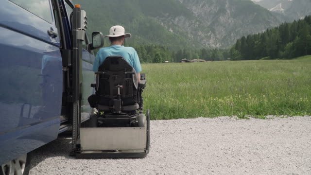 4k-Auflösung-Video-von-einem-Mann-auf-dem-Rollstuhl-gehen-aus-einem-Auto-auf-Elektro-Aufzug-Spezialfahrzeug-für-Menschen-mit-Behinderungen.-Selbsthilfe-für-Behinderte-Konzept
