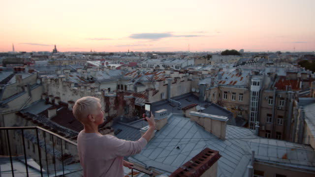 Frau-auf-dem-Dach-stehen-und-Fotos-machen