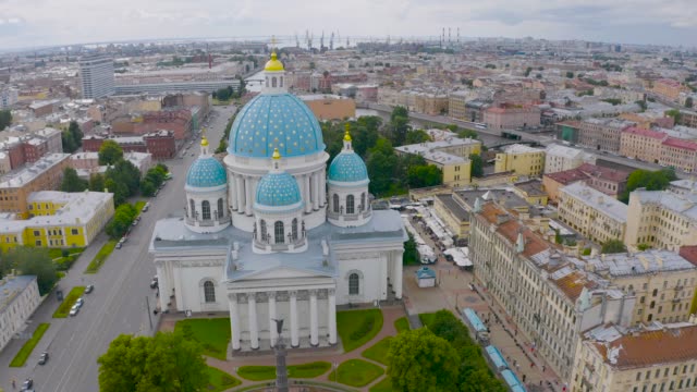 La-famosa-Catedral-de-la-Trinidad-con-cúpulas-azules-y-estrellas-doradas,-vista-de-la-parte-histórica-de-la-ciudad-de-San-Petersburgo,-casas-típicas-alrededor