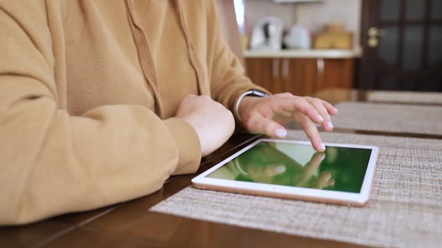 Mädchenfinger-drehen-Seiten-auf-einem-Tablet-mit-einem-grünen-Bildschirm