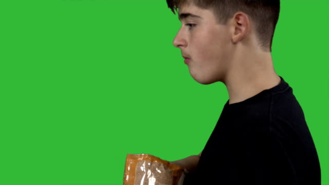 junge-Essen-Kartoffelchips-auf-grünem-Hintergrund.-Teenboy-Essen-Junk-food