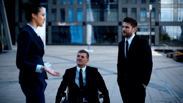 Unternehmer-im-Rollstuhl-ungültig-deaktiviert,-aber-sehr-glücklich-im-Gespräch-mit-seinen-Kollegen