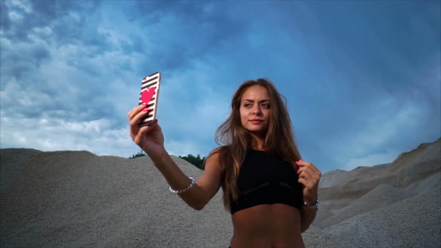 Young-woman-photographes-herself-on-a-smartphone-after-a-fitness-session