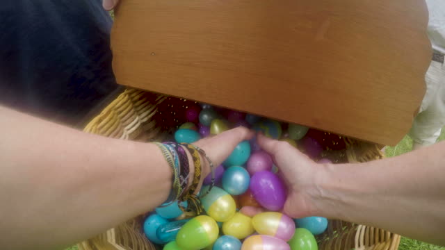POV-of-a-woman's-hands-reaching-into-an-Easter-basket-and-grabbing-eggs