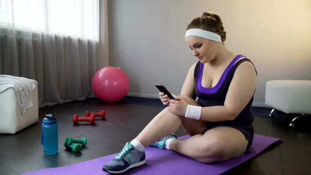 Mädchen,-die-Überprüfung-ihrer-Gewichtsverlust-Ergebnisse-in-mobilen-Sportanwendung-auf-smartphone