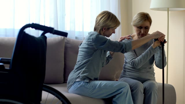 Weibliche-Psychologen-unterstützen-einsam-Behinderte-ältere-Frau-im-Pflegeheim