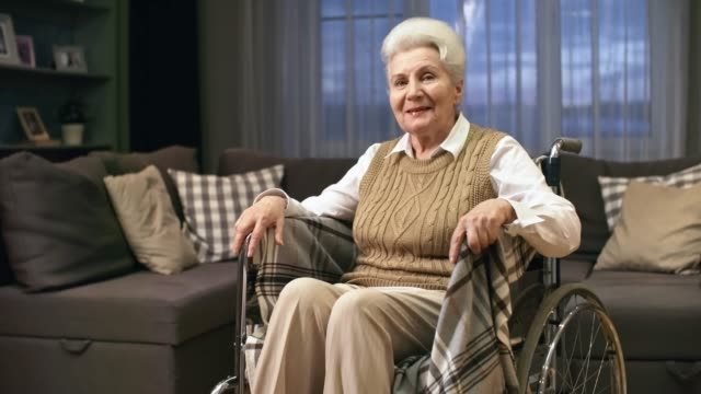 Ältere-Frau-im-Rollstuhl-winken-Hallo