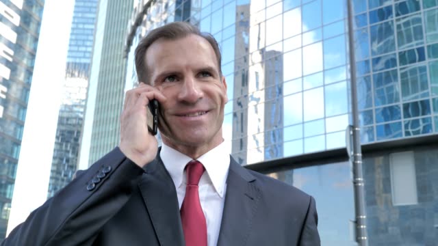 Walking-Middle-Aged-Businessman-Talking-on-Phone