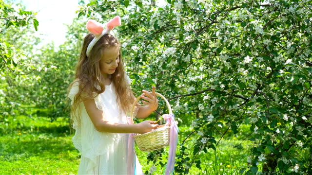 Adorable-little-girl-in-blooming-apple-garden-on-beautiful-spring-day