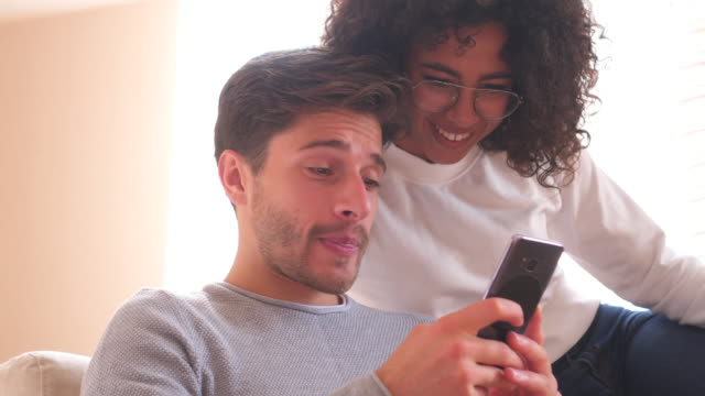 Glückliches-Paar-genießen-Sie-Medieninhalte-auf-Handy