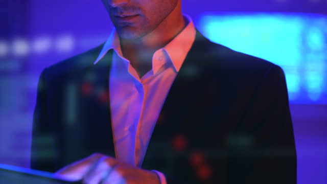 Der-hübsche-Geschäftsmann,-der-mit-einem-Tablet-auf-dem-Hologramm-Hintergrund-arbeitet