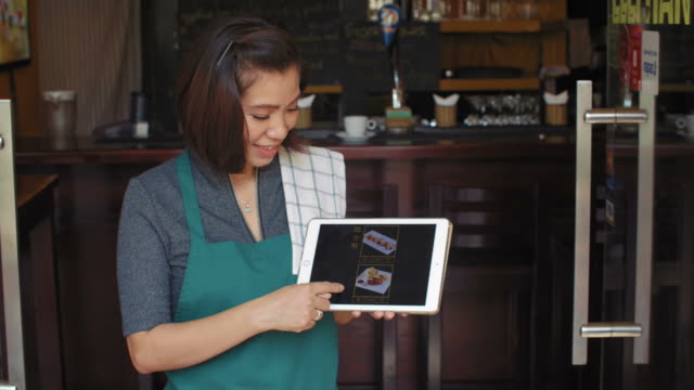 Waitress-Showing-Menu-On-Tablet