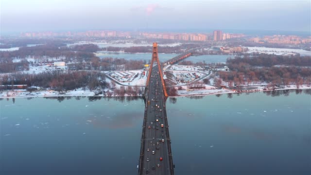 Aerial-view-of-Northern-Bridge-and-the-Dnieper-River-of-the-city-of-Kiev-at-sunset-in-winter,-Ukraine