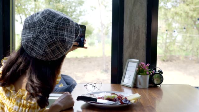 Asiatische-junge-Frau-fotografiert-Frühstück-mit-Smartphone-Social-Media