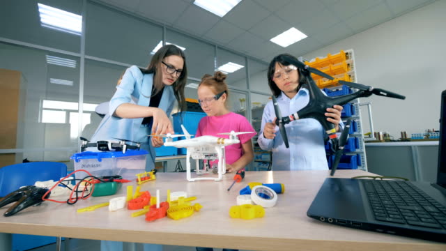Female-teacher-study-innovative-technologies---drones,-aircraft-at-primary-school.-Modern-education-concept.