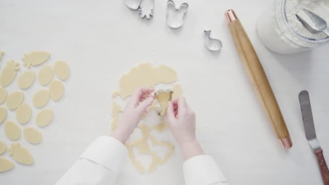 Cutting-sugar-cookie-dough-with-Easter-shaped-cookie-cutters.