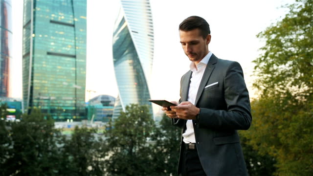 Young-caucasian-man-holding-smartphone-for-business-work.