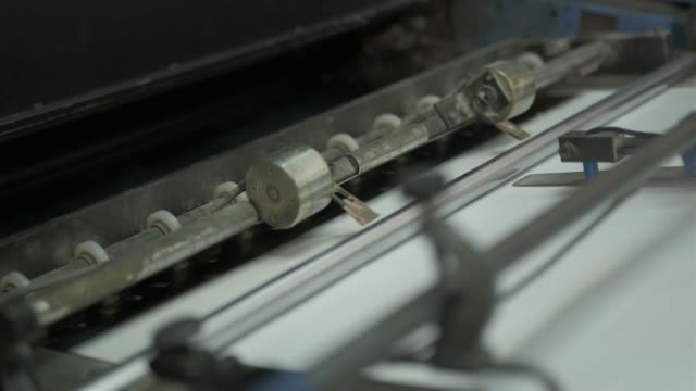 Videoclip-de-la-fábrica-de-impresión.-Máquina-para-alimentar-el-papel-en-funcionamiento.-Detalles-de-los-equipos-modernos.