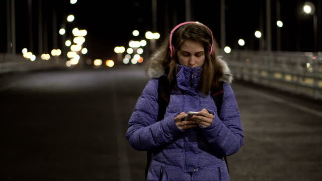 Das-Mädchen-vom-Smartphone-ist-nachts-in-der-Stadt,-spricht-in-sozialen-Netzwerken