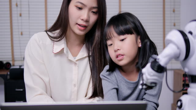 Lehrer-lehrt-kleine-Mädchen-über-progarming-Roboter-durch-Computer.-Mädchen-mit-Trainingskurs,-um-Hardware-mit-Lehrer-zu-entwickeln.