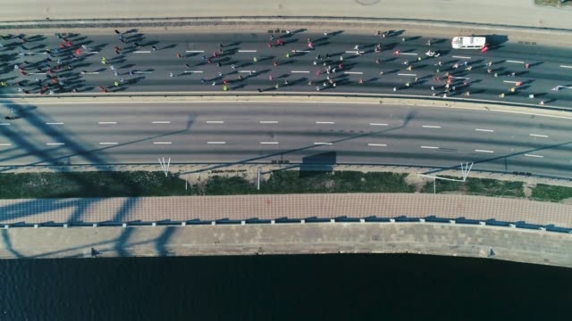 Marathon-running-along-seafront-at-morning.-Top-view-shot