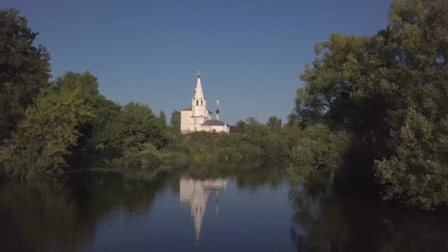 Vuelo-sobre-el-río-y-hermosa-iglesia-en-Suzdal.-Rusia.-Vista-aérea-desde-drones