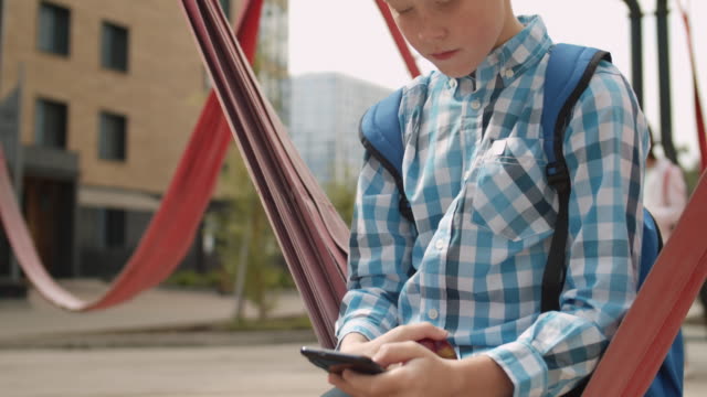 Schoolboy-Using-Phone-Outdoors