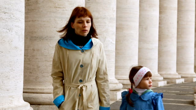 Mujer-con-su-hija-caminando-entre-columnas-en-Piazza-San-Pietro,-Vaticano